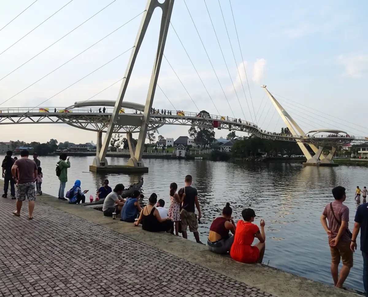 People relaxing by the Sarawak River near Darul Hana Bridge, Kuching